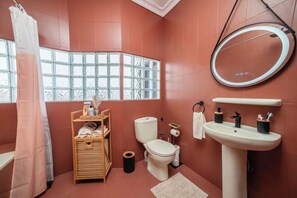 Ein Badezimmer mit Toilette, Waschbecken und einem Fenster mit Blick.