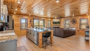Interior espaçoso de cabana com cozinha, sala de jantar e sala de estar.