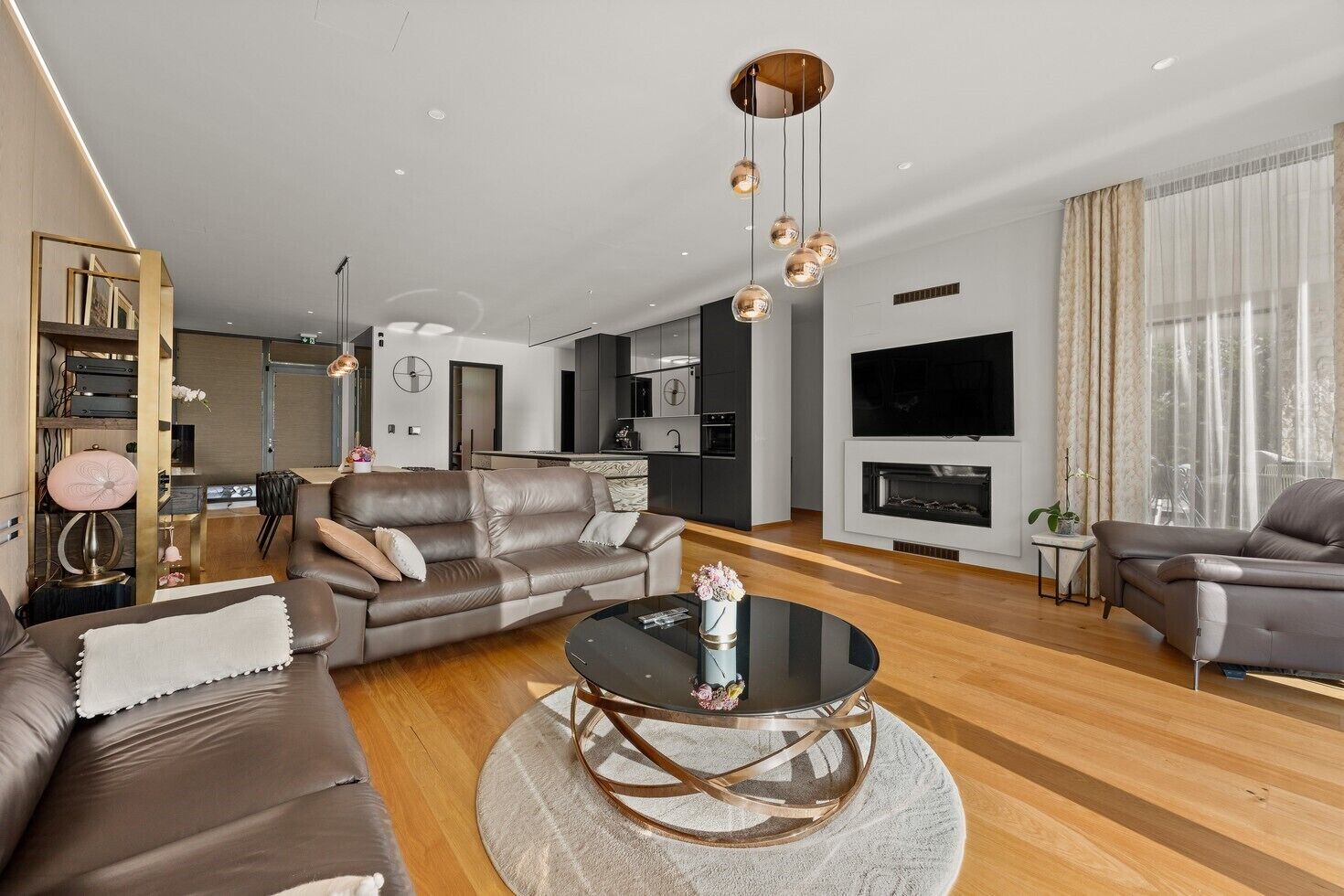 Un salon moderne avec un canapé, une table basse et un téléviseur.
