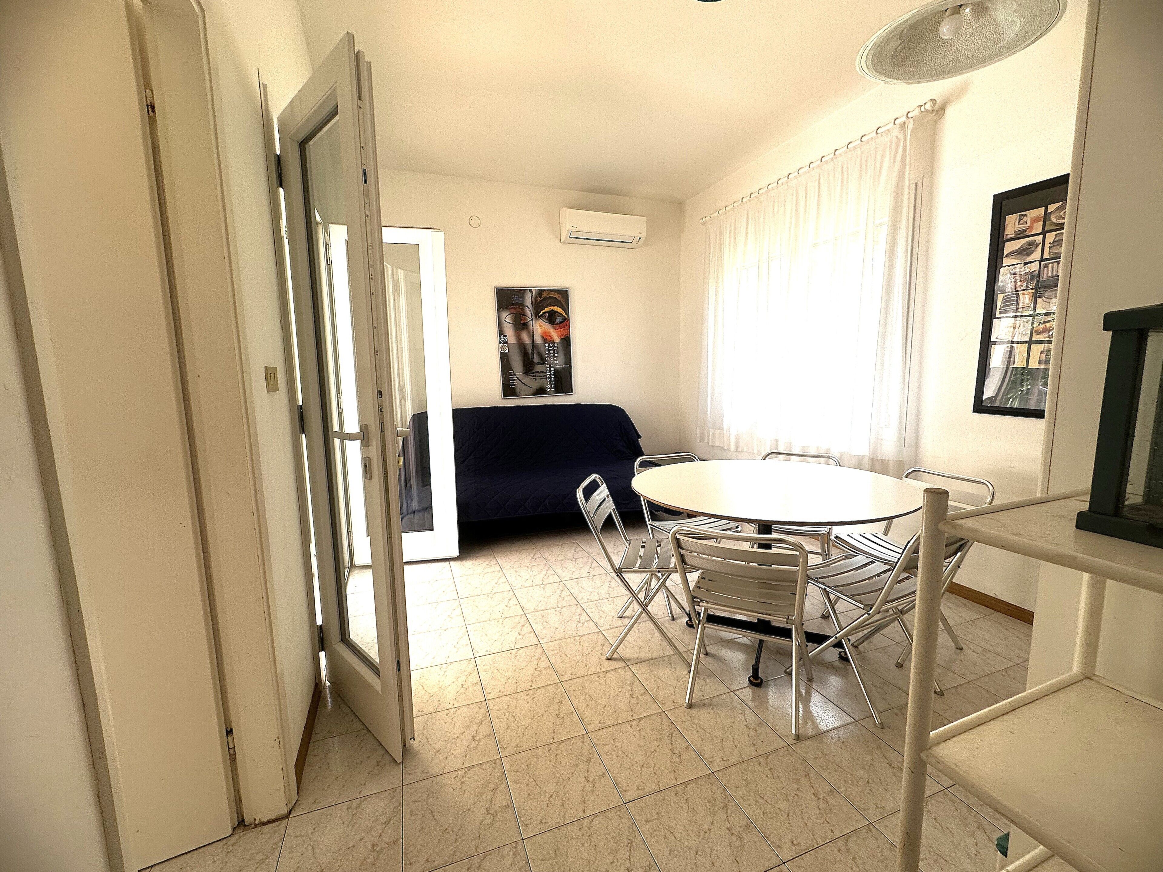 Um quarto com uma mesa redonda, cadeiras, um sofá e uma cama.