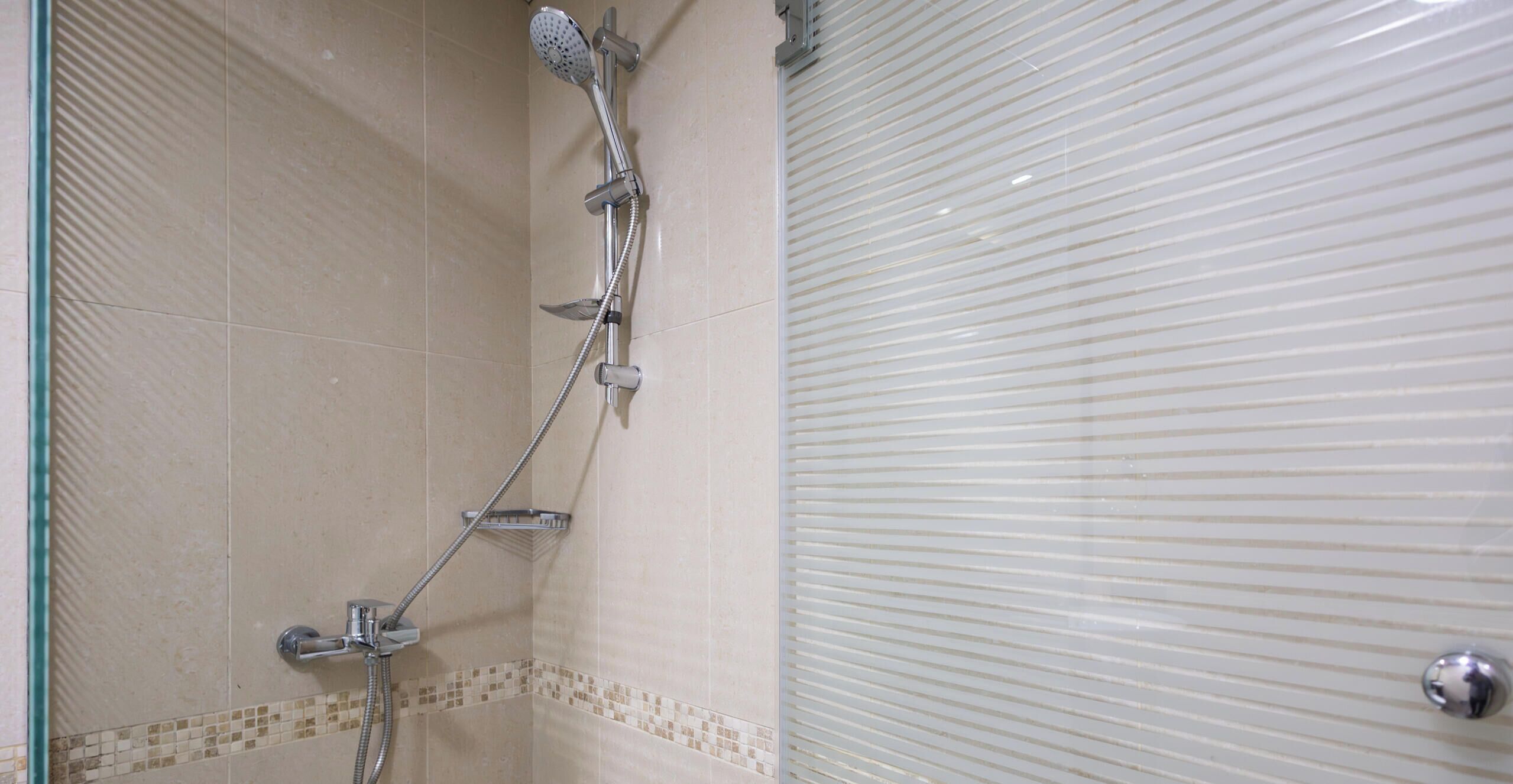 Ducha con cabezal de ducha de mano y grifo empotrado.