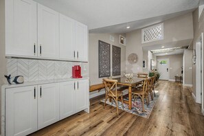 A modern kitchen with white cabinetry, a red coffee machine, and a herringbone tile backsplash. - 3 min walk to beach/Heated Pool/Games/Kids area (Clearwater Beach)