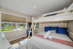 A room with bunk beds, a window with blinds, a ladder, and a bed with a quilt and pillows. - 3 min walk to beach/Heated Pool/Games/Kids area (Clearwater Beach)