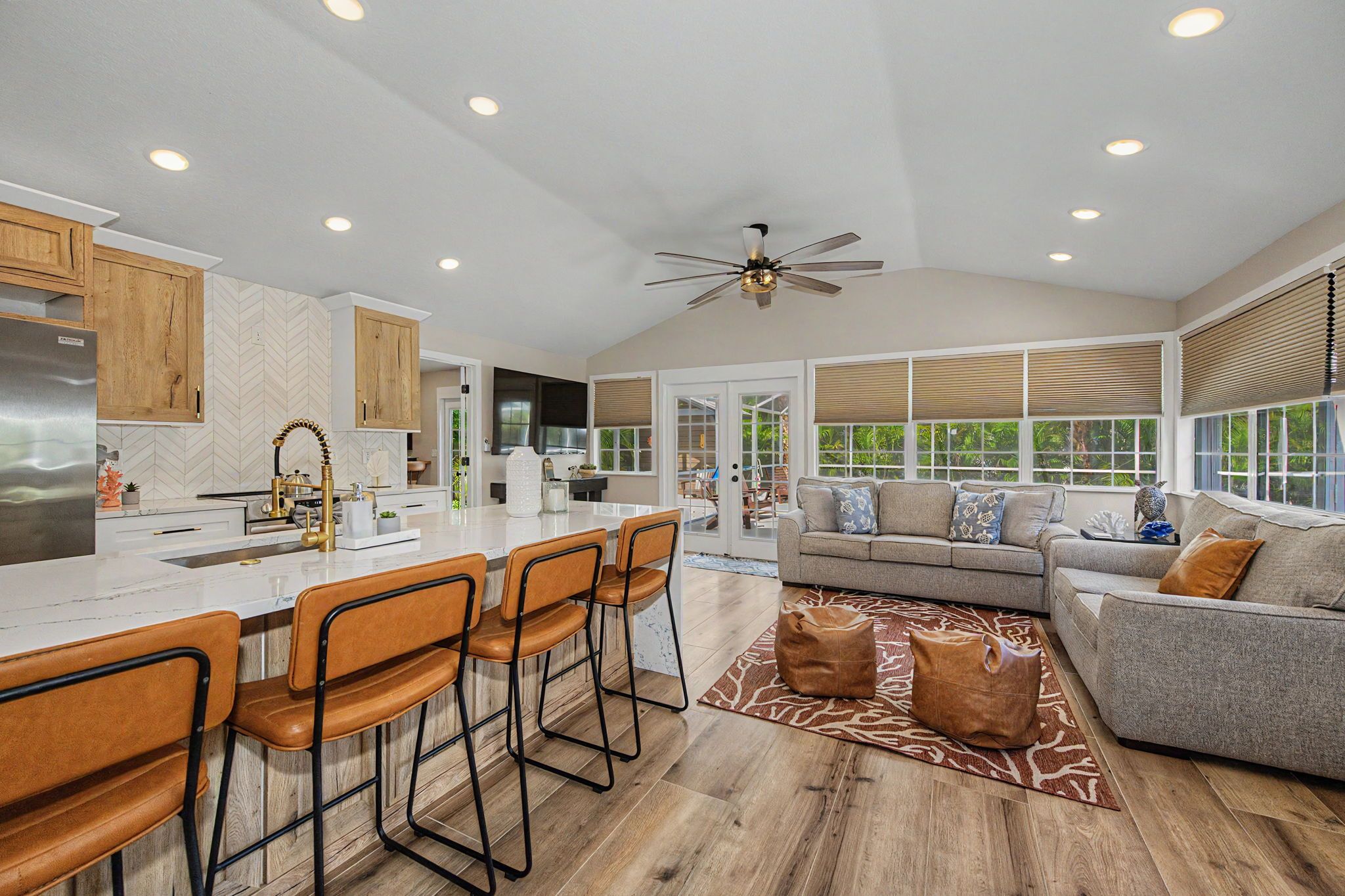 A spacious kitchen with a central island, wooden cabinets, and a ceiling fan.