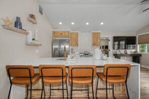 A modern kitchen with a central island, wooden cabinets, and a built-in oven. - 3 min walk to beach/Heated Pool/Games/Kids area (Clearwater Beach)