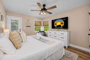 A bedroom with a bed, a ceiling fan, a TV, and a window with blinds. - 3 min walk to beach/Heated Pool/Games/Kids area (Clearwater Beach)