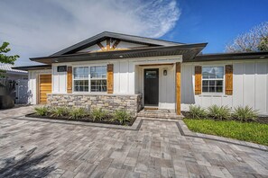A modern house with a stone foundation, a front porch, and a garage. - 3 min walk to beach/Heated Pool/Games/Kids area (Clearwater Beach)