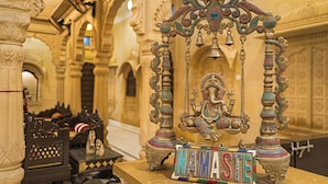 Un sanctuaire religieux orné, avec une cloche suspendue et une pancarte sur laquelle on peut lire « NAMASTE ».