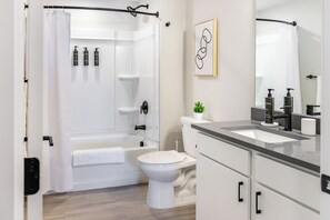 A modern bathroom with a bathtub, toilet, and sink. - Landing Furnished Apartments near Downtown Salt Lake (Salt Lake City)