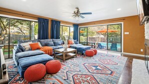 A spacious living room with a large sectional sofa, a coffee table, and a patterned rug. - Resort Oasis w/ Pool | Hot Tub | Mini Golf & Games (San Antonio)