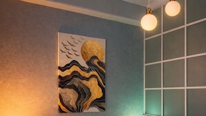 Un dormitorio con cama, dos lámparas de noche, una obra de arte en la pared y una ventana con persianas.