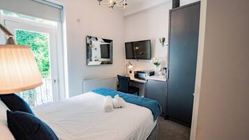 Une chambre d’hôtel avec un lit, un bureau, une télévision et une fenêtre.