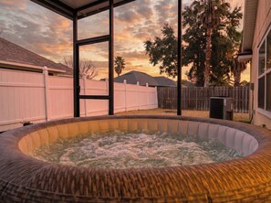A hot tub with a view of a sunset and a wooden fence in the background. - *25% OFF | Long Term Friendly / Central Location | Pets Welcome* (Jacksonville)