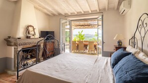Ein Schlafzimmer mit Bett, Schreibtisch und Blick ins Freie.