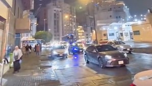 A nighttime city street with buildings, cars, and a prominent tower with a clock. - Al-Orabi Hotel (Makkah)