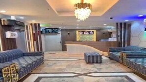 A hotel lobby with a reception desk, sofas, a chandelier, and a patterned floor. - Al-Orabi Hotel (Makkah)