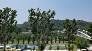 A park with trees, a bridge, and a swimming pool. - Flora Guest House (Rome)