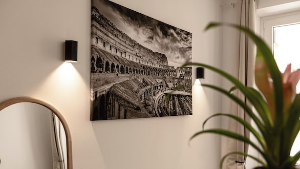 A black and white photograph of the Colosseum with a modern light fixture on the wall. - Flora Guest House (Rome)