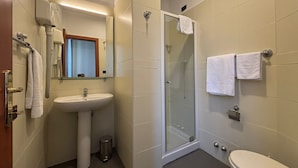 Et badeværelse med bruseniche, håndvask og toilet.