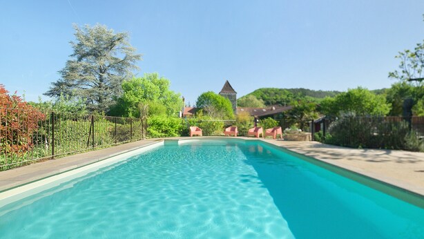 Une piscine aux eaux cristallines, avec un bâtiment visible en arrière-plan.