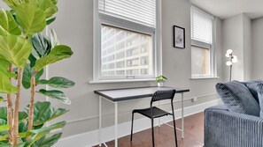 Een moderne kamer met een bureau, stoel en een grijze bank.