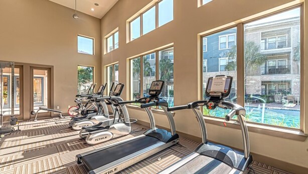 A gym with treadmills, exercise bikes, and a pool view. - Landing Amazing 1bd, Clubhouse, Gym (Houston)