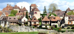 Un antico borgo con architettura tradizionale, mura in pietra e un fiume.