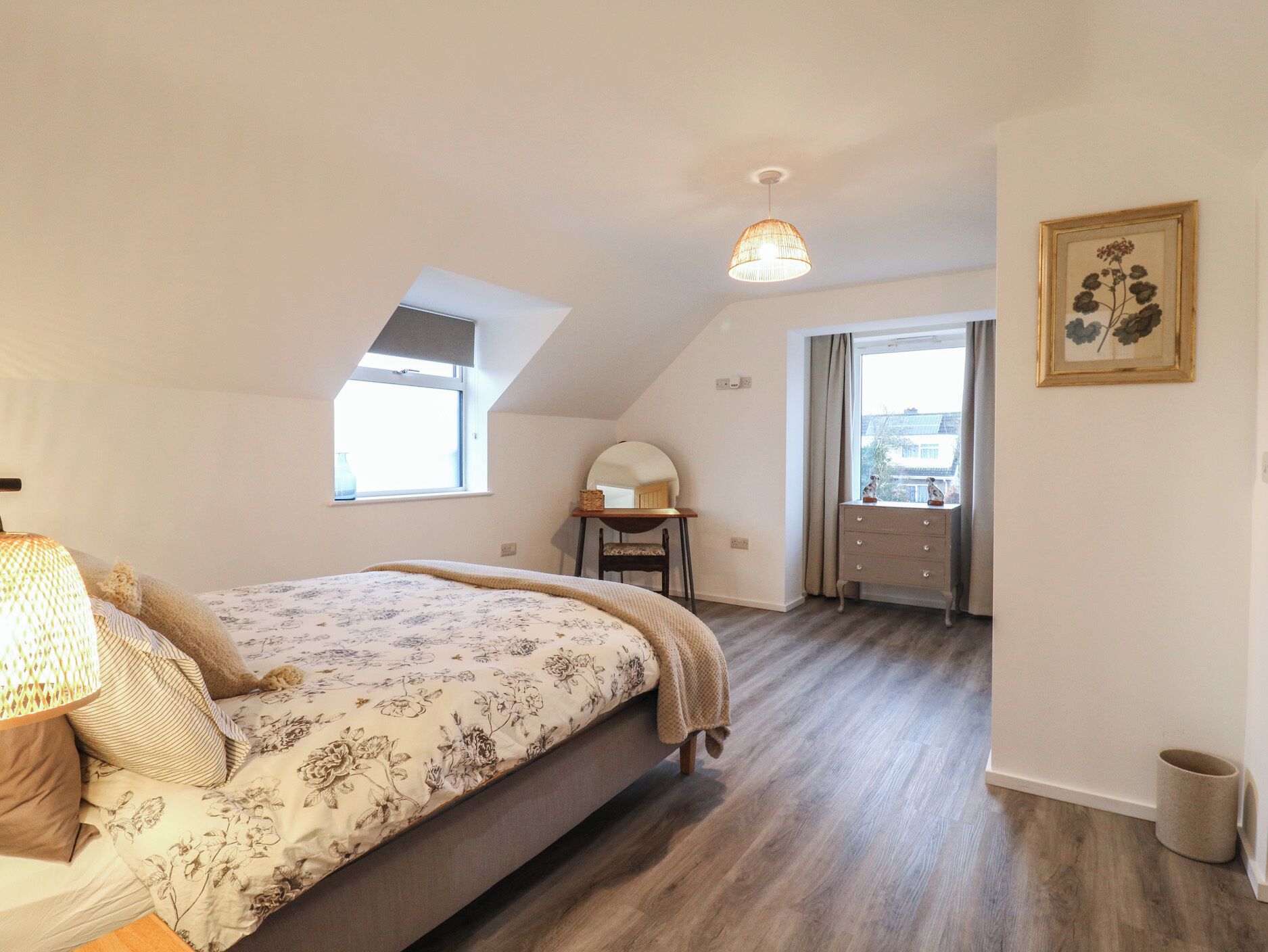 A bedroom with a bed, a desk, a chair, a window, and a door.