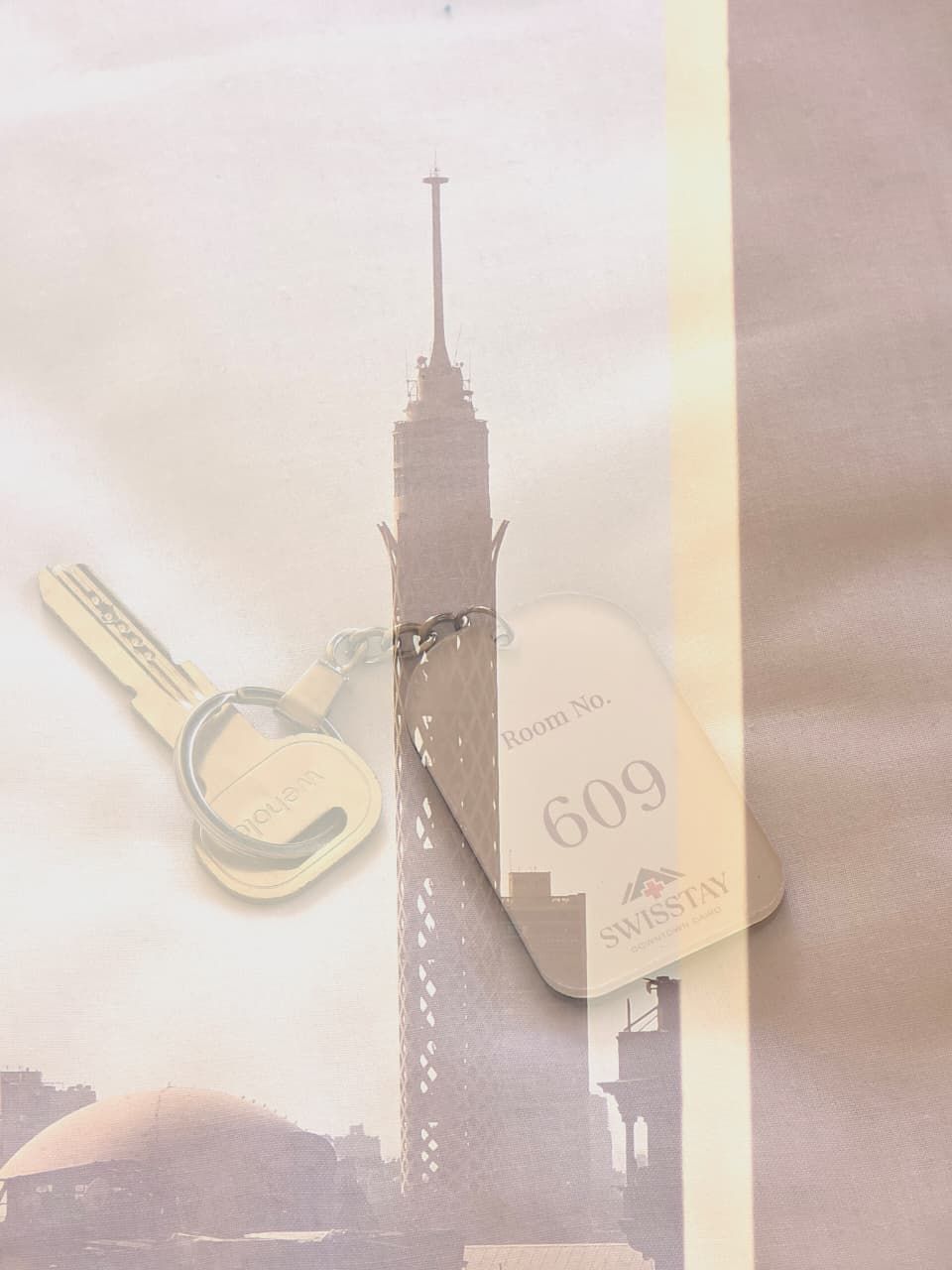 A keychain with a key and a hotel room tag labeled "Room No. 609" and "SWISSSTAY".