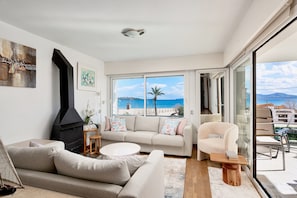 A modern living room with a sofa, coffee table, and a fireplace. - Ancora - Frontline Apartment with Stunning Views (Port de Pollença)