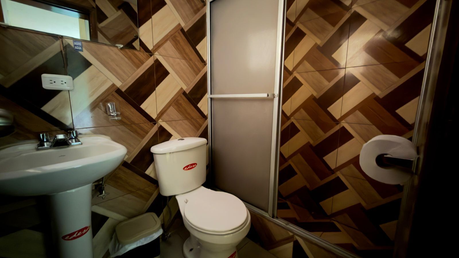 Un baño con lavamanos, inodoro y ducha.