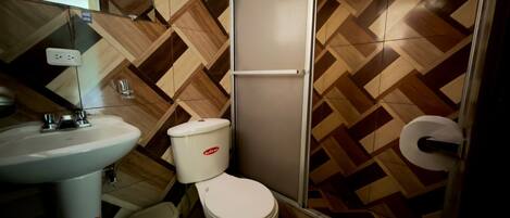Un baño con lavamanos, inodoro y ducha.