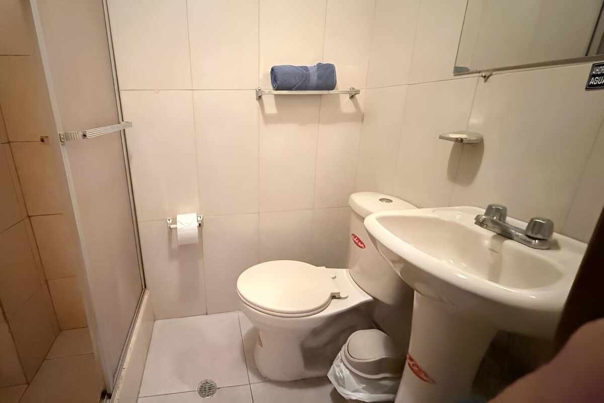 A small bathroom with a toilet, sink, and a towel rack.