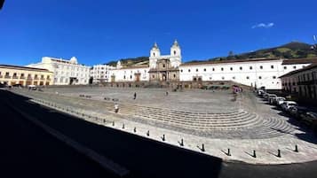 A large open plaza with a central staircase leading to a building with two towers.