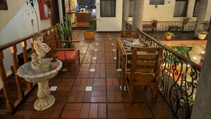 A spacious indoor area with a staircase, wooden furniture, and potted plants. - Hostal Viena Internacional (Quito)