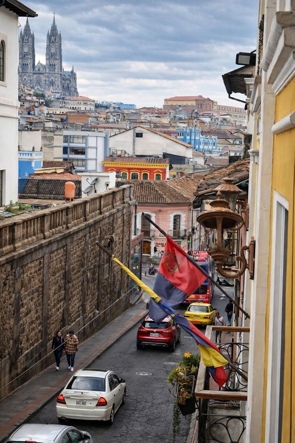 A narrow street with a flag, cars, and buildings.