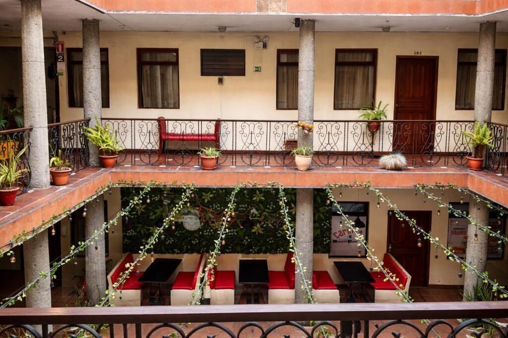 A courtyard with a central seating area, potted plants, and a wooden door.