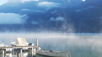 Un barco amarrado en un muelle con montañas al fondo.