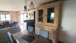 Ein gemütlicher Wohnbereich mit einer Couch, einem Esstisch und Holzschränken.