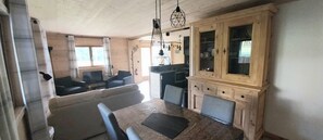 Una sala acogedora con sofá, mesa de comedor y armarios de madera.