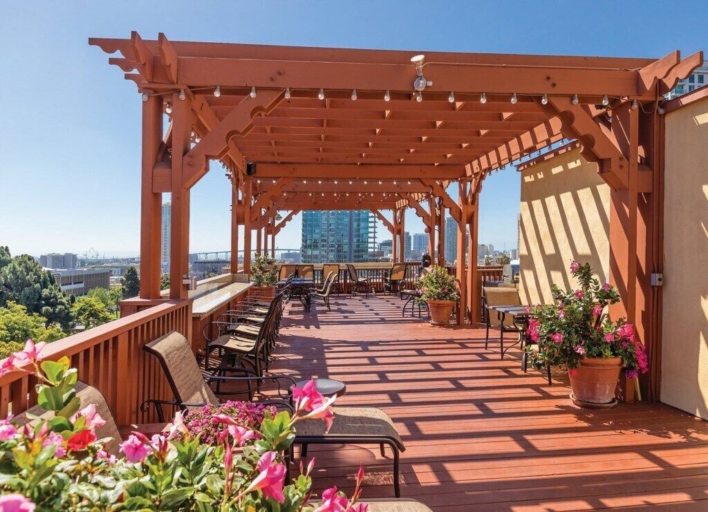 Un patio al aire libre con muebles de madera y plantas en macetas.