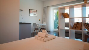 Een moderne hotelkamer met een bed, een bureau en een zithoek.