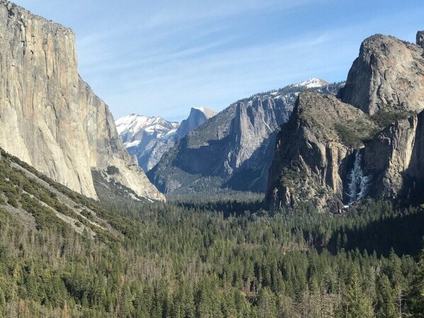 Un paisaje montañoso con bosque denso y acantilados rocosos.