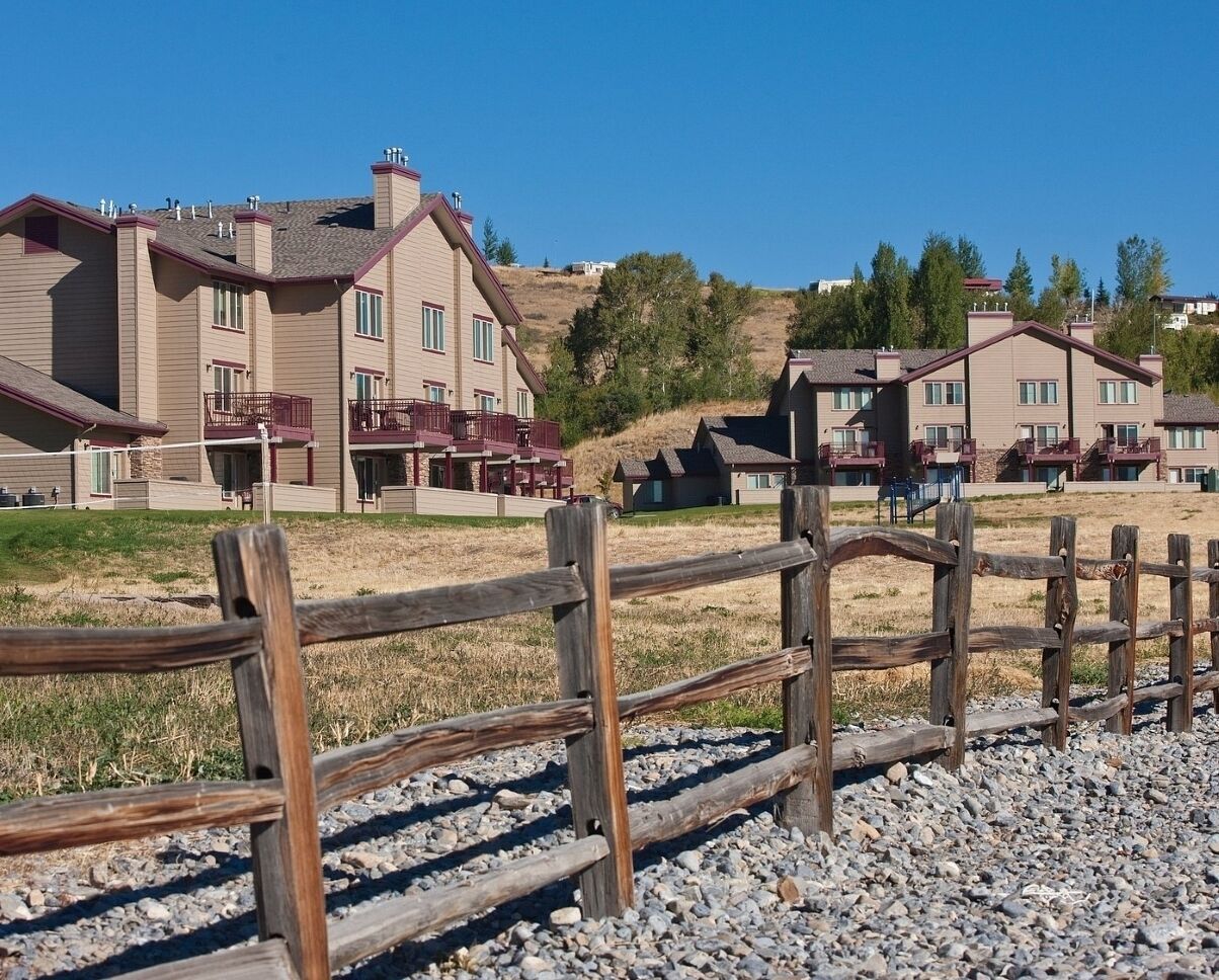 Zona residencial con varias casas de dos pisos, con balcones y una valla de madera al frente.