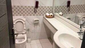 A modern bathroom with a toilet, bidet, and sink.