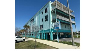 A multi-story building with a sign indicating '200' and 'Condominium'. - Condo in Gulf Shores with great location. Walk everywhere, 3mins from the beach. (Gulf Shores)