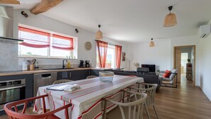 A modern kitchen with a dining area, wooden beams, and pendant lighting. - Cottage in the Basque Mountains with View, Wi-Fi and Air Conditioning (Ossès)