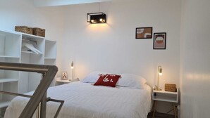 A bedroom with a bed, bedside tables, a wall-mounted light, and a staircase. - At sandra&fred your vacation in the dream of our cokon (Calvi)