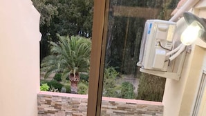 A balcony with a glass door, two white chairs, a round table, and two black stools. - At sandra&fred your vacation in the dream of our cokon (Calvi)