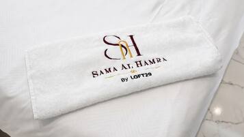 Almohada blanca con texto bordado y un logo.
